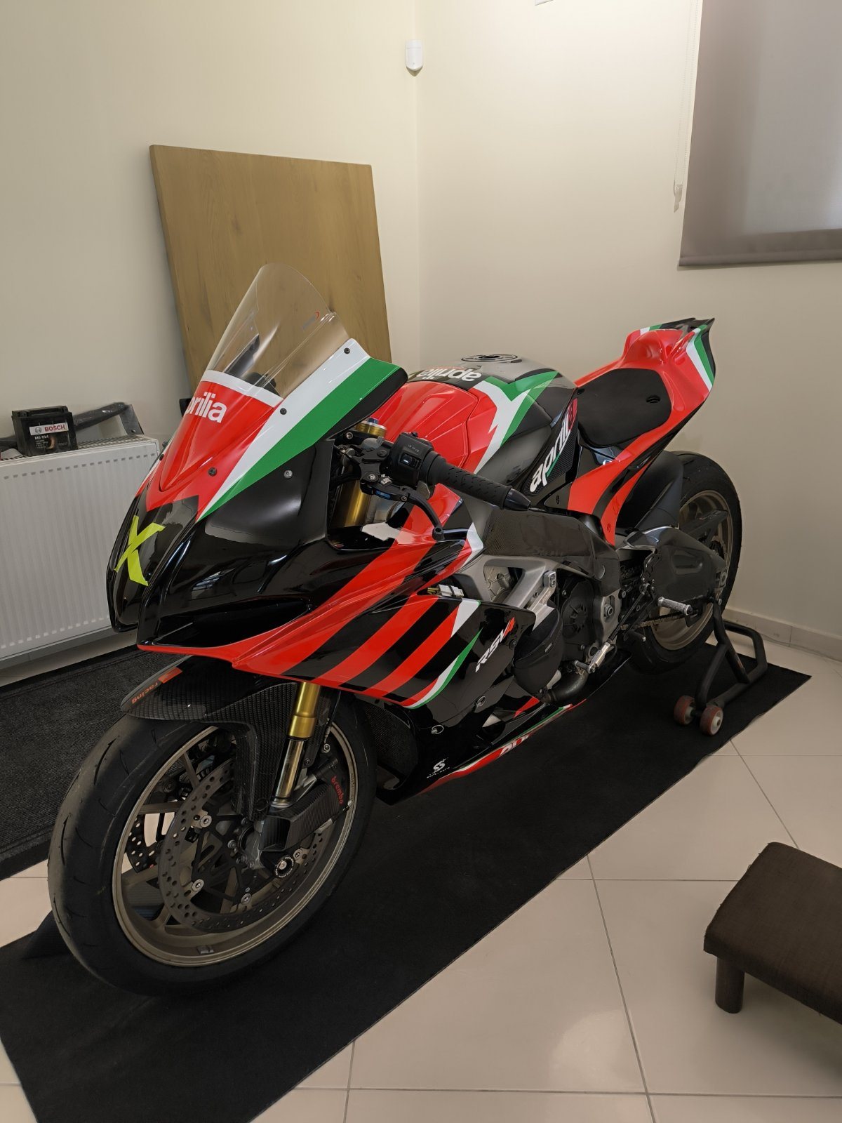 Aprilia RSV4 from the rear three-quarter, with diagonal black stripes sweeping across the tail