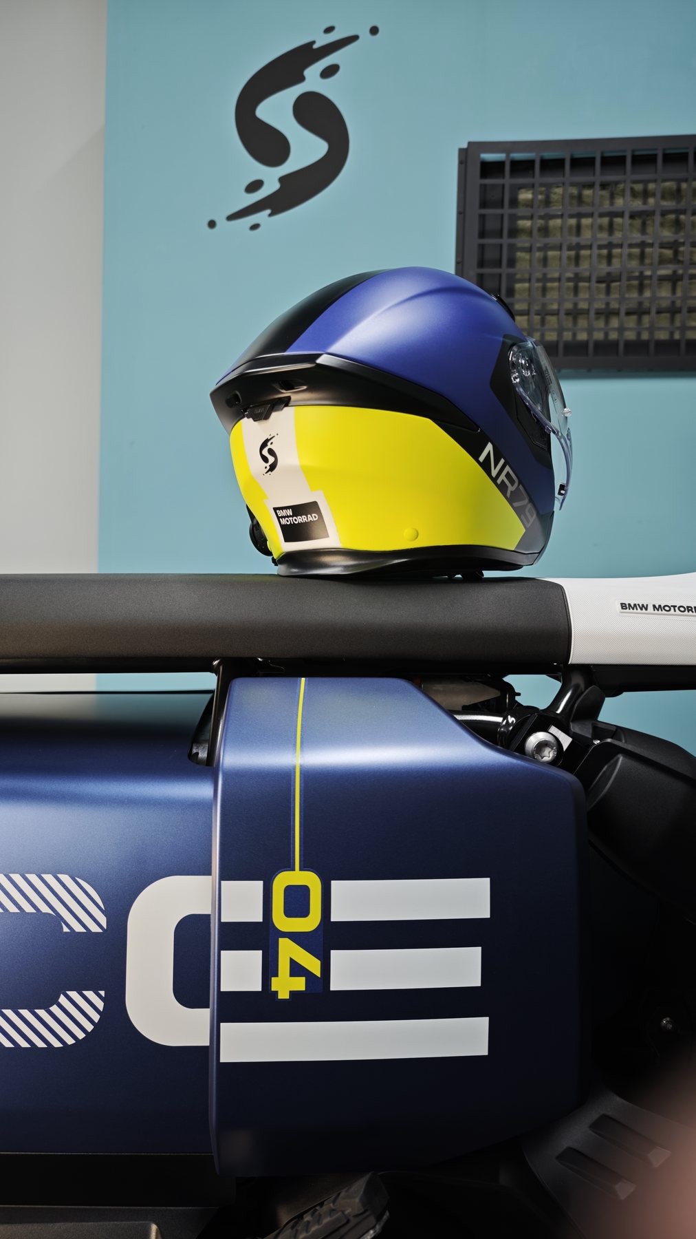 The BMW CE 04 scooter with its matching blue and yellow helmet resting on the handlebar