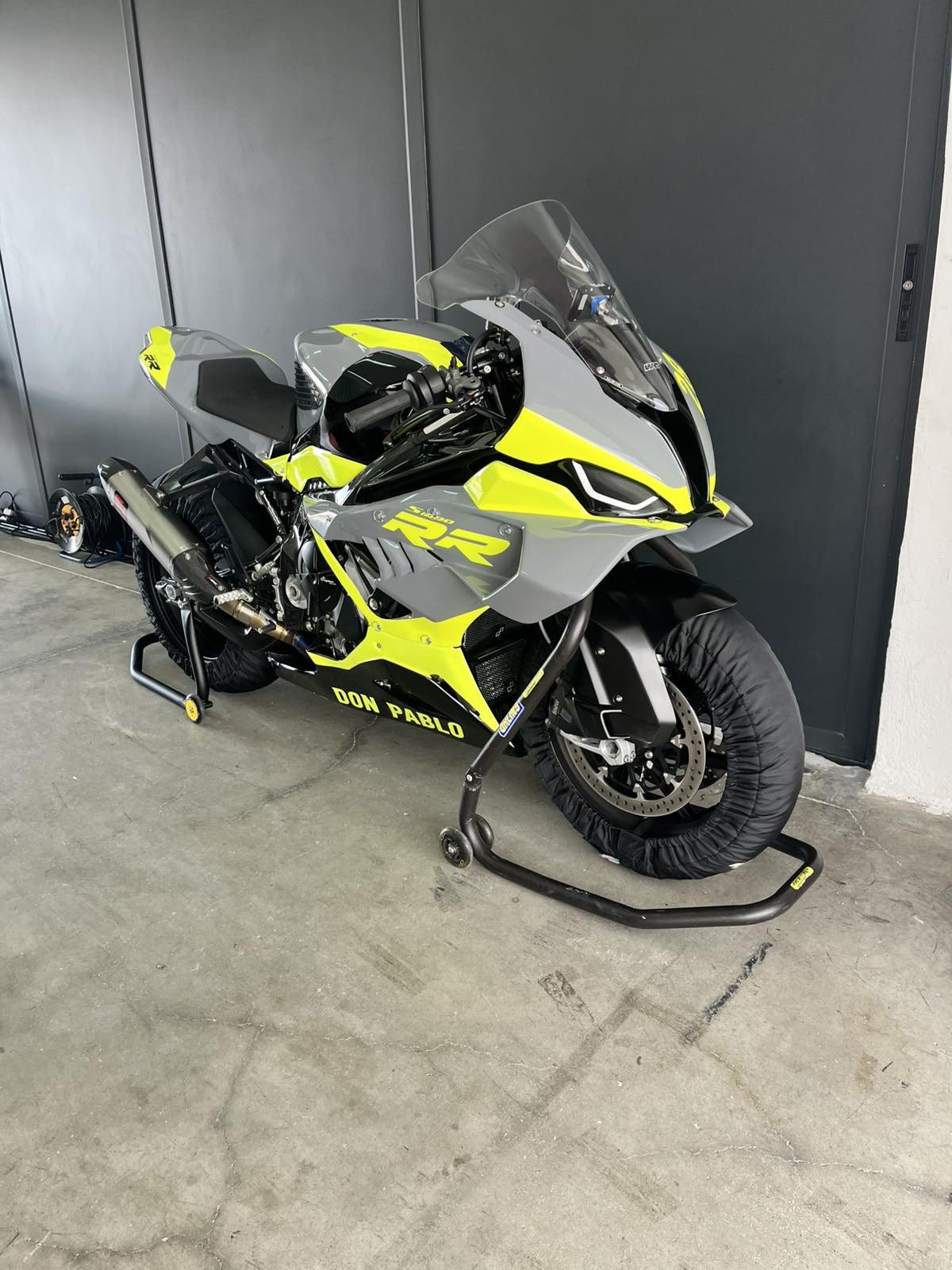 The BMW S1000RR on paddock stands, showing the fluorescent yellow, grey and black fairing