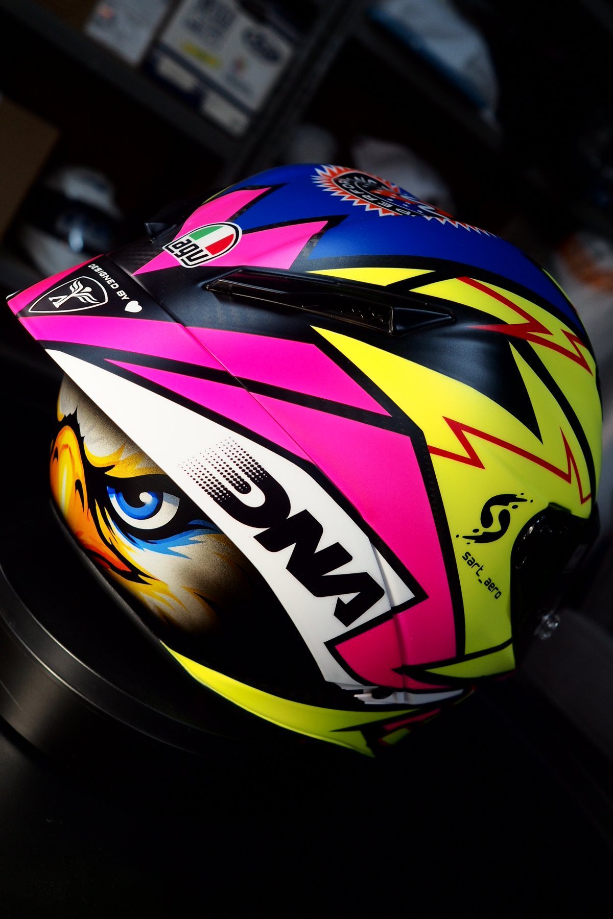 Side view of the Dinos 31 2026 helmet in fluorescent yellow and magenta with the eagle eyes on the brow