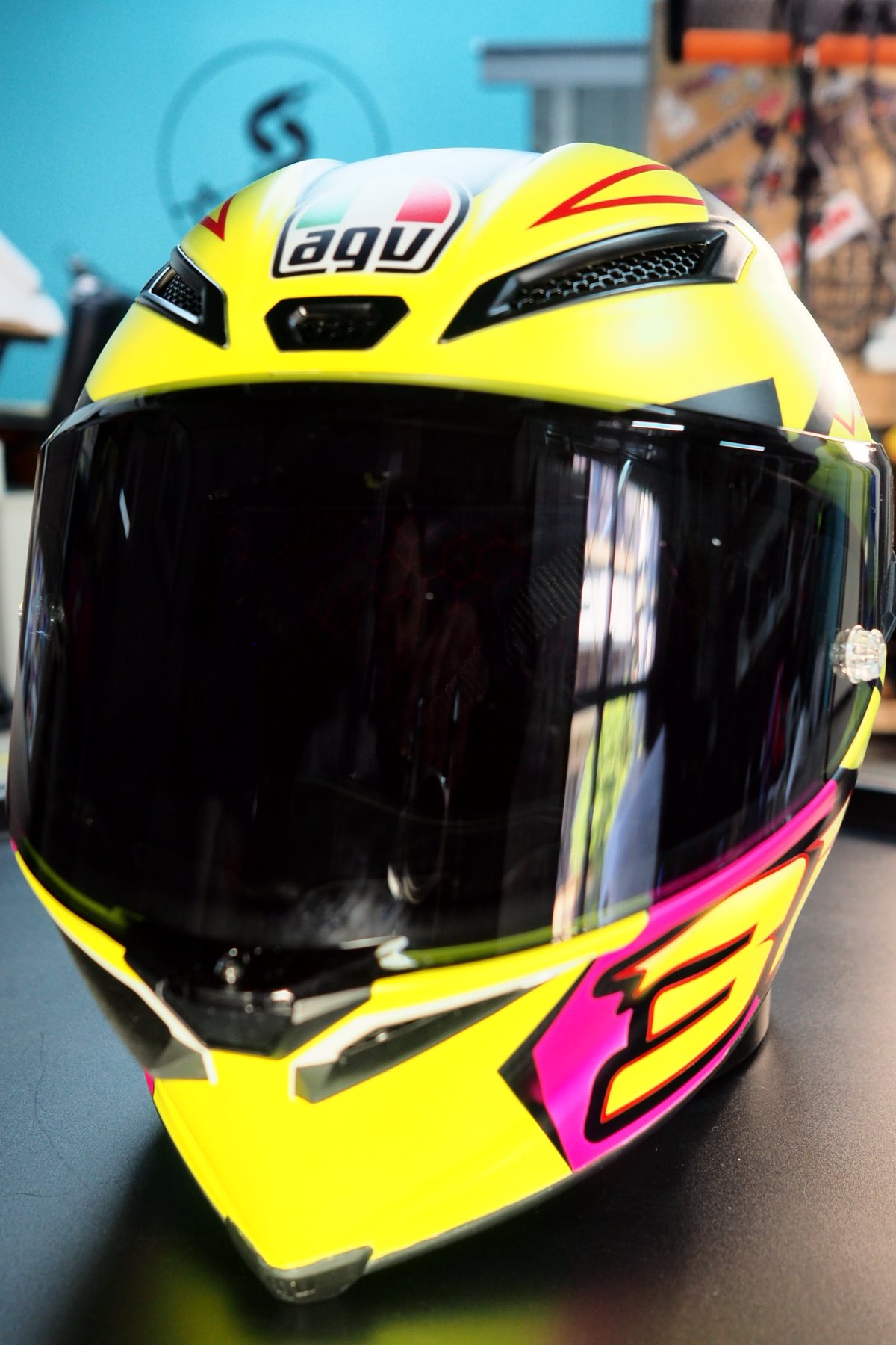 Front view with the dark visor down and the magenta chevrons across the chin