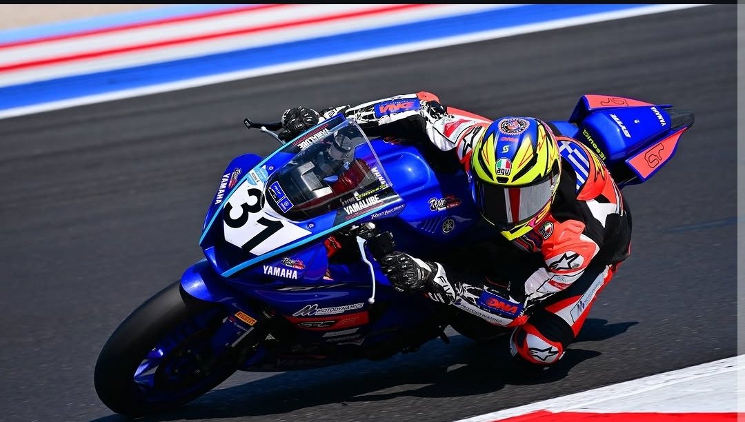 On-track action shot of bike and rider mid-corner with the 31 helmet visible