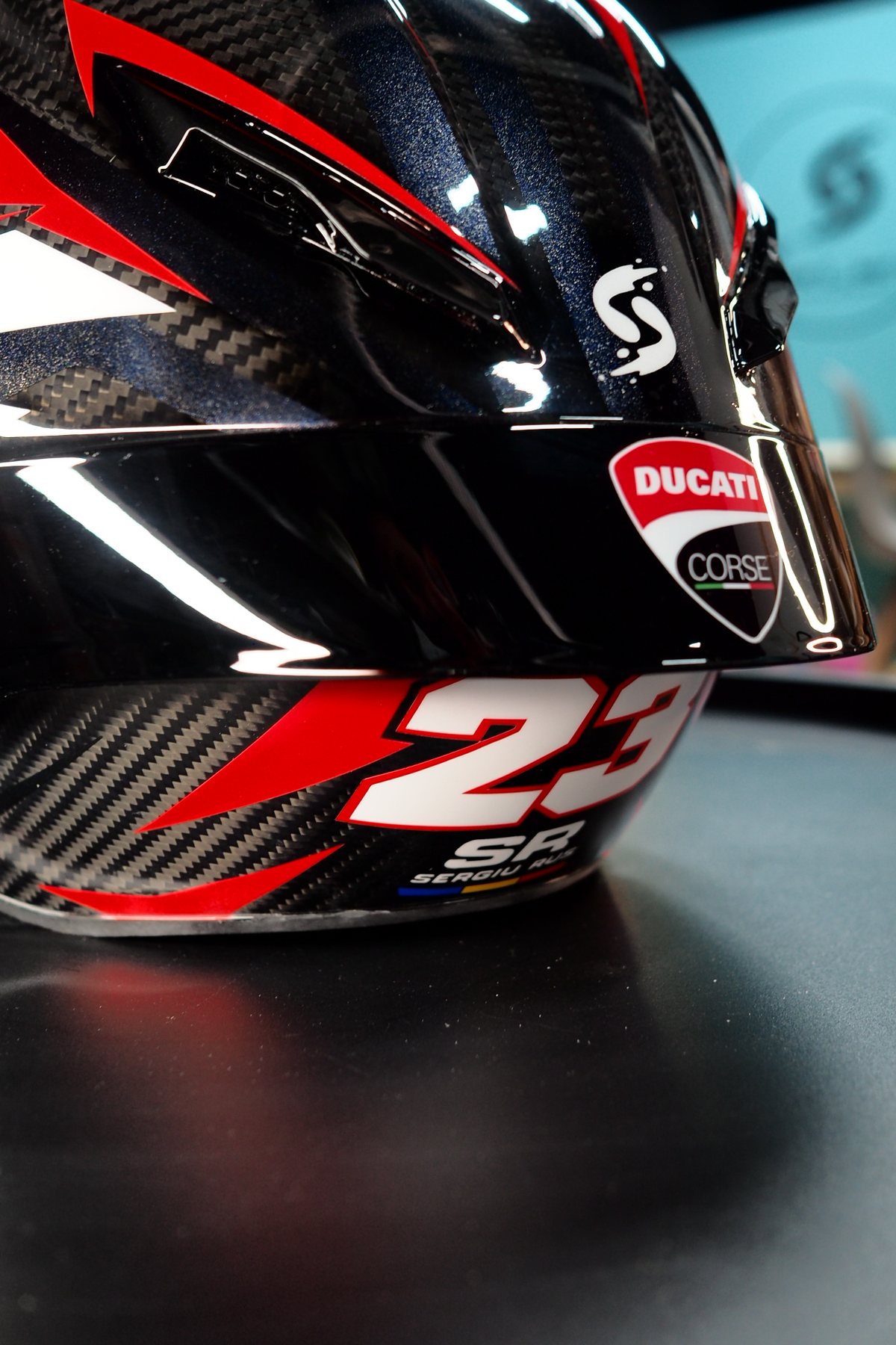 Side view of the Ducati #23 helmet with the Ducati Corse shield at the lower edge