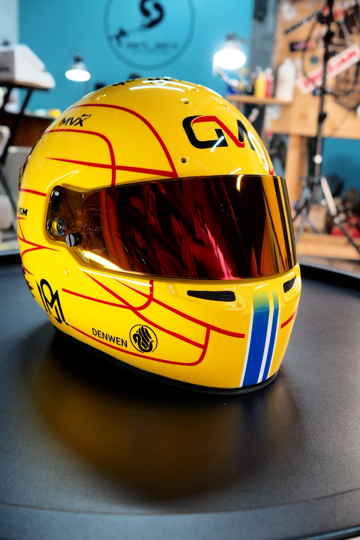 Left side of the helmet showing the yellow shell and sponsor marks