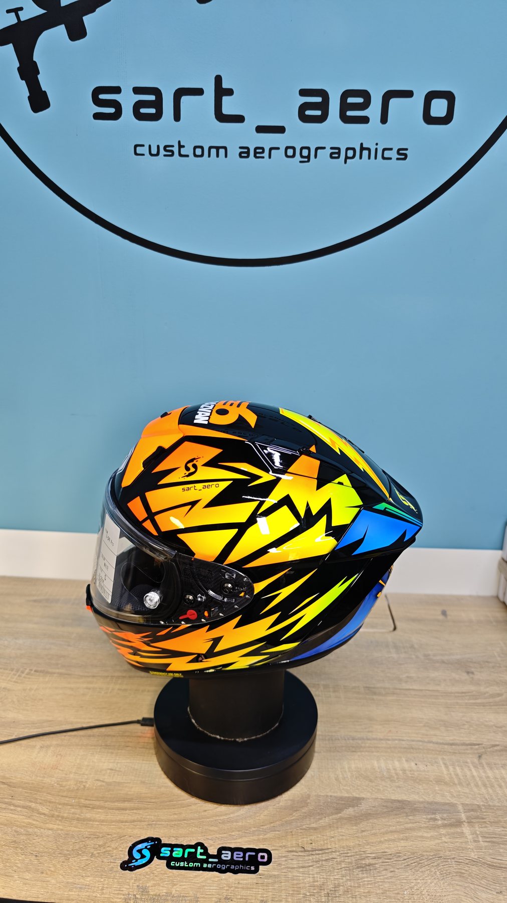 Front three-quarter view with the orange and yellow shards radiating around the visor