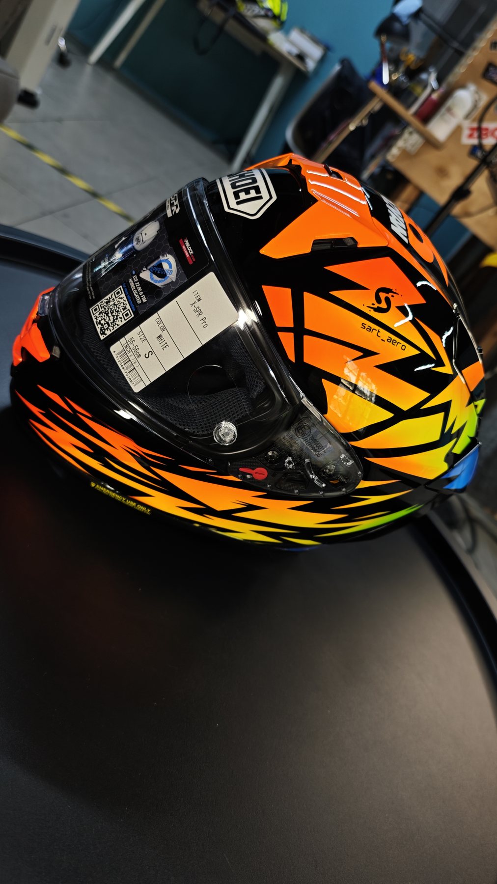 Side view of the helmet on a dark table, lightning shards running across the shell