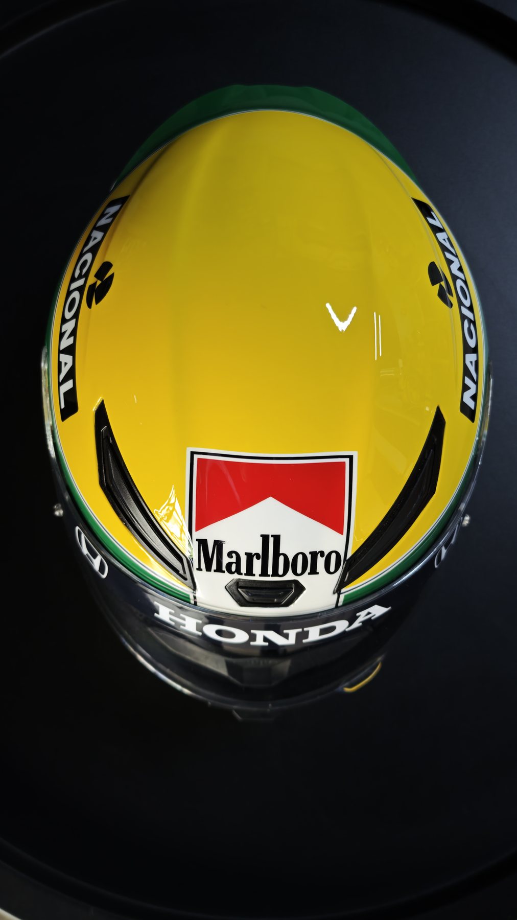 Overhead view of the Senna Replica helmet showing the yellow crown and period graphics