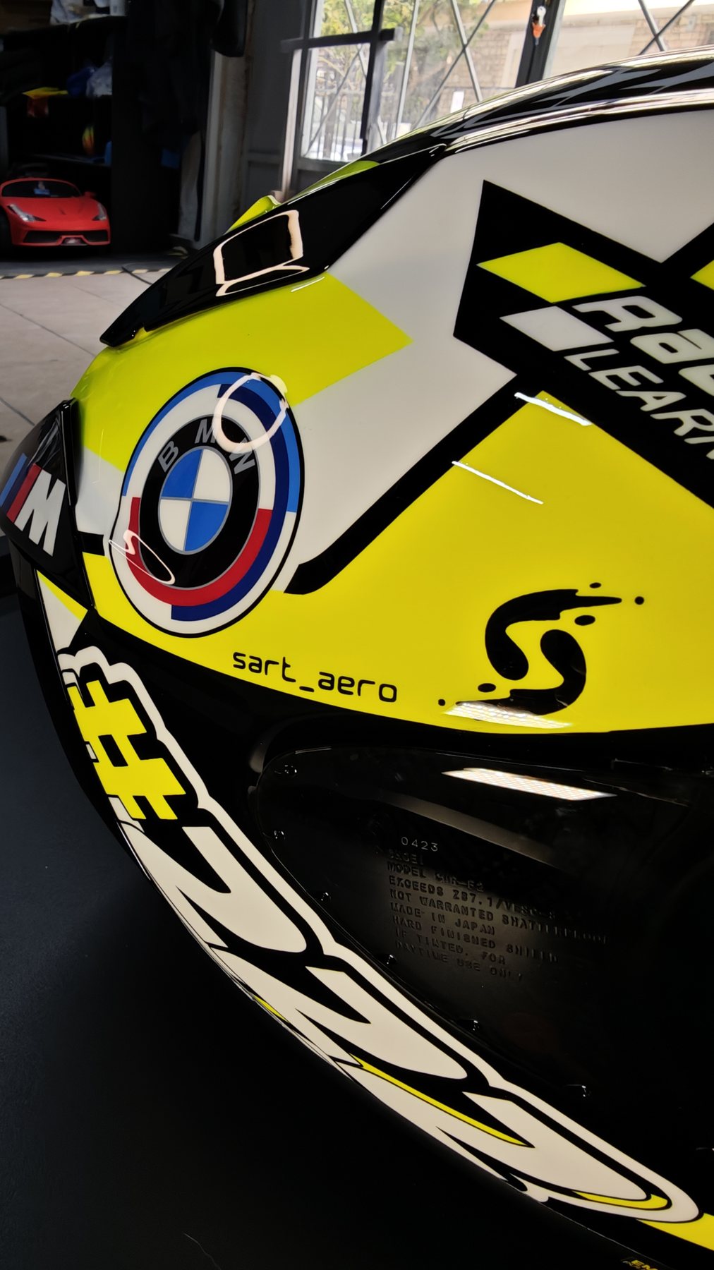 Close-up of the Shai 222 helmet brow showing the BMW roundel, the outlined 222 number and the sart_aero signature