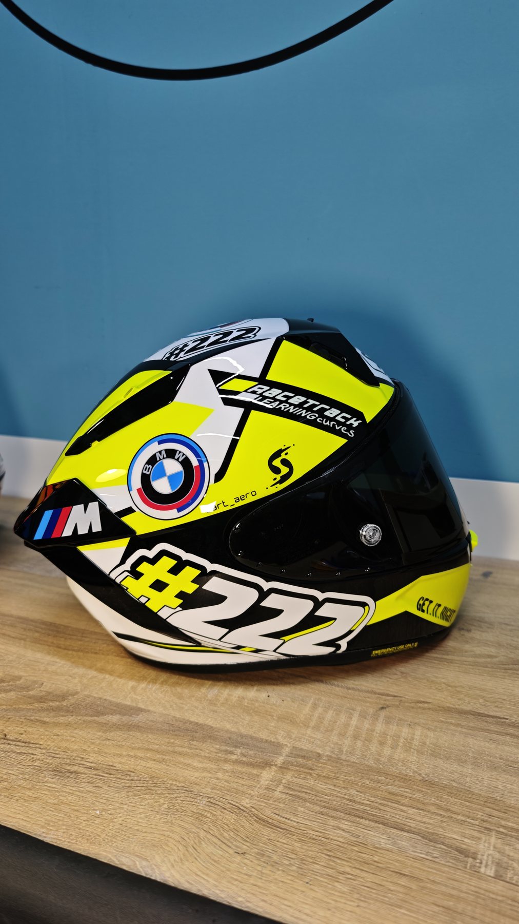 Front three-quarter of the Shai 222 helmet with dark visor, fluorescent yellow chevrons and the 222 number